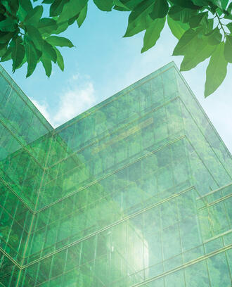 A big building that appears green with trees