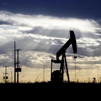  The sun shines through the clouds as it begins to set behind a pumpjack, March 30, 2022, outside of Goldsmith, Texas. 