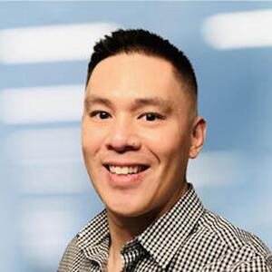 Headshot of a man with a checkered shirt.